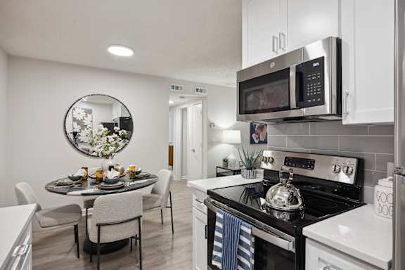 A modern kitchen with a dining table and chairs at St. Andrews Reserve Apartments in Wilmington, NC
