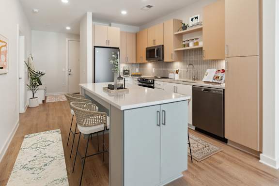 A kitchen with a white island and a refrigerator at Hawkins Press, Charlotte, North Carolina