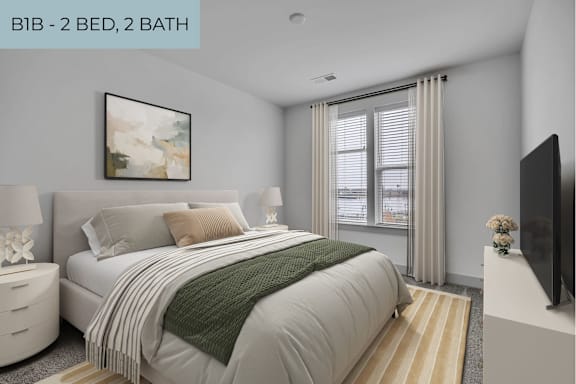 A bedroom with a large bed and a flat screen TV on the wall.