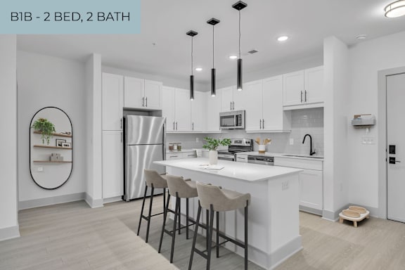 A modern kitchen with a white countertop and bar stools.