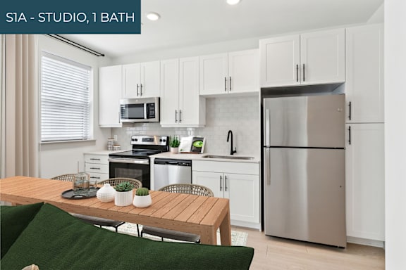 A modern kitchen with a wooden table and stainless steel appliances.