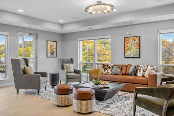 A living room with a brown couch, grey armchairs, and a coffee table.