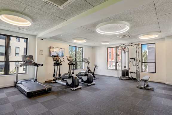 A gym with treadmills, exercise bikes, and other equipment.