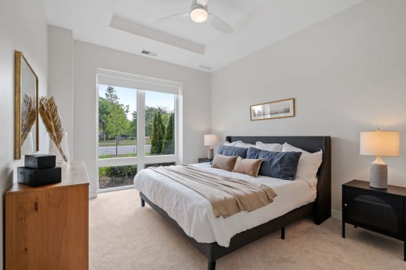 a bedroom with a large window and a large bed