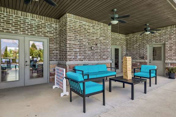 A patio with a brick wall and a blue couch.