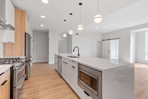 Expansive Kitchen Island with Overhead Lighting