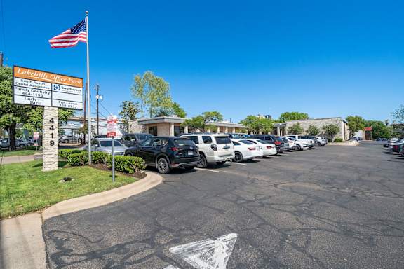 A parking lot with cars and a sign that says "La Cuevita Office Park".