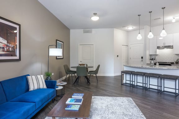 a living room with a blue couch and a table with chairs