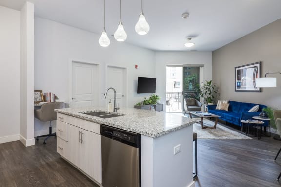 a kitchen with an island and a living room with a couch and a television