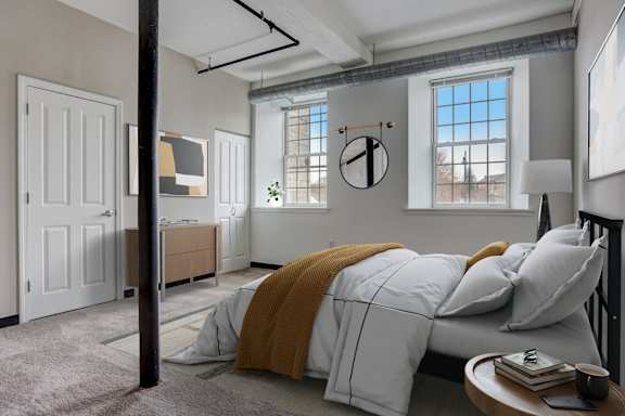 a bedroom with a bed and two windows