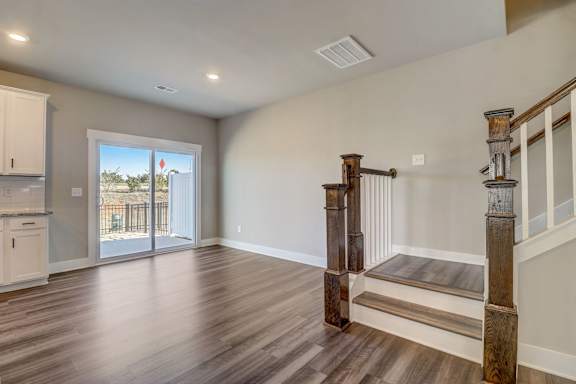A room with wooden floors and a staircase with a wooden handrail.