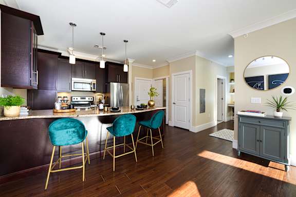 A kitchen with dark brown cabinets and a white countertop.