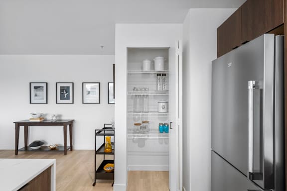 a small kitchenette with a refrigerator and shelves