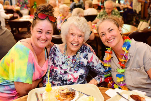 a large dining room with tables and chairs and windows at River Commons Senior Living, Redding, CA