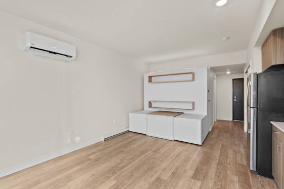 A kitchen with a black fridge and a white wall.