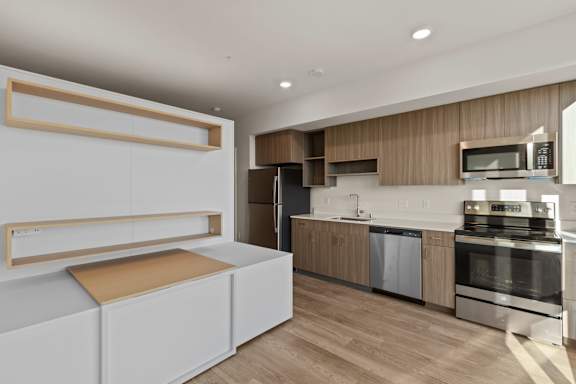 A modern kitchen with wooden cabinets and stainless steel appliances.