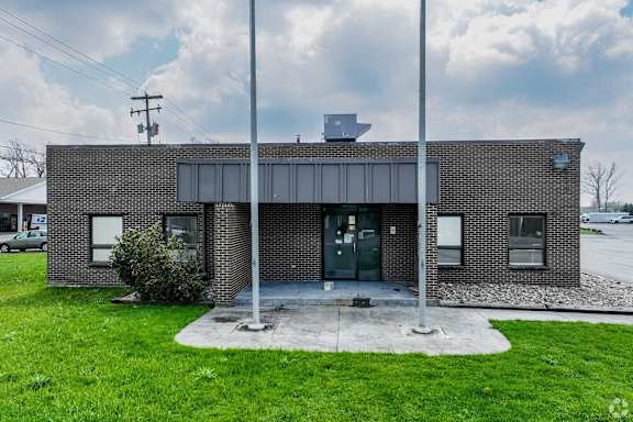 a brick building with two flag poles in front of it