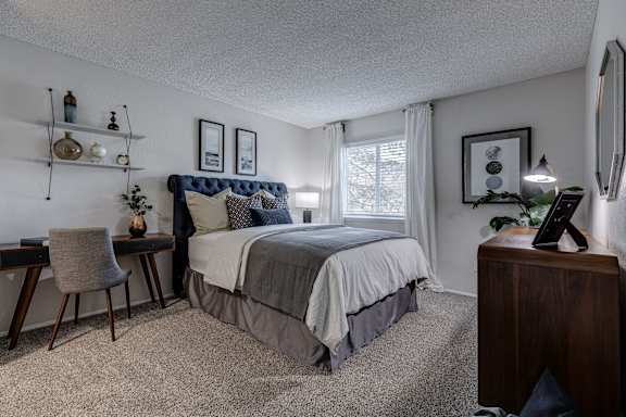 a bedroom with a bed and desk in a room