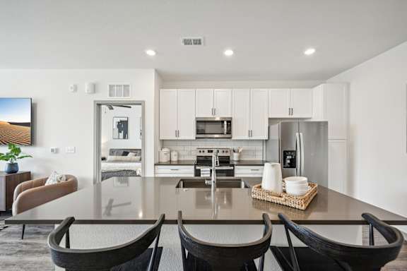 a kitchen and dining room with a table and chairs at The Quarry Luxury Apartment Homes, Fort Collins, CO, 80526