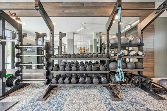 a gym with weights and balls on a rack at The Quarry Luxury Apartment Homes, Fort Collins, CO, 80526