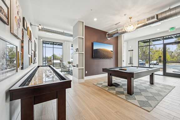a billiards room with a pool table and a large window at The Quarry Luxury Apartment Homes, Fort Collins, CO, 80526