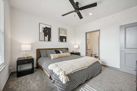 a bedroom with a bed and a ceiling fan at The Quarry Luxury Apartment Homes, Fort Collins, 80526