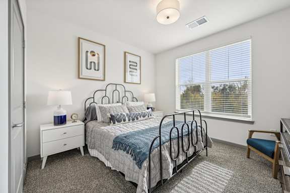 a bedroom with a bed and a large window at The Quarry Luxury Apartment Homes, Fort Collins, CO, 80526