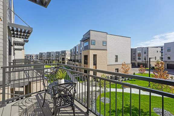 A balcony with a table and chairs at Meridian at CityPlace, Woodbury, MN 55125