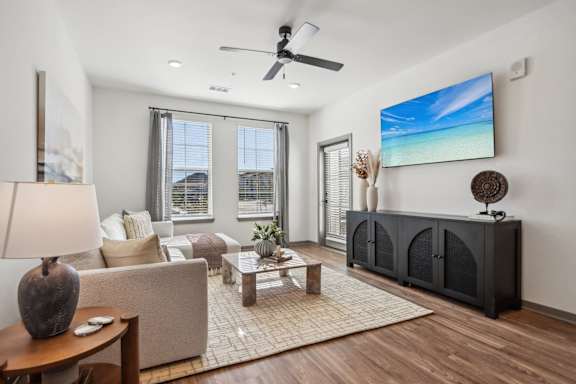 a living room with a fireplace and a ceiling fan at Stella Luxury Apartment Homes, San Tan Valley, AZ, 85143