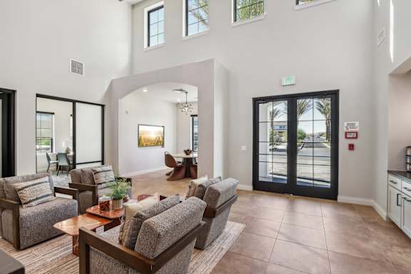 a living room with couches and chairs and a door to a lobby