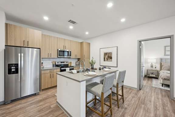 a kitchen with a large island and a stainless steel refrigerator at The Garrison Luxury Apartment Homes, Colorado, 80817