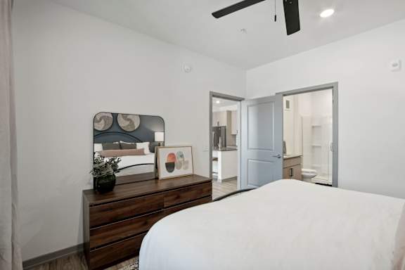 a bedroom with a large white bed and a wooden dresser at The Maddox Luxury Apartment Homes, Arizona, 85326