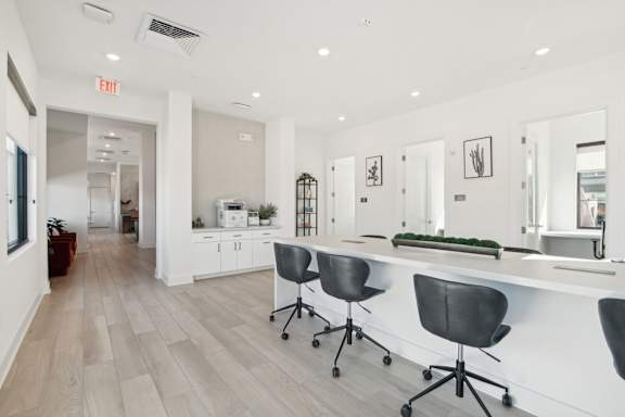 a white office with a long counter and chairs at The Maddox Luxury Apartment Homes, Arizona, 85326