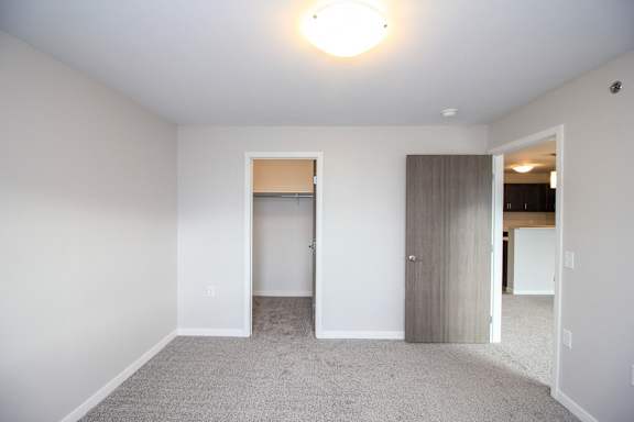 A room with a grey carpet and a white door.