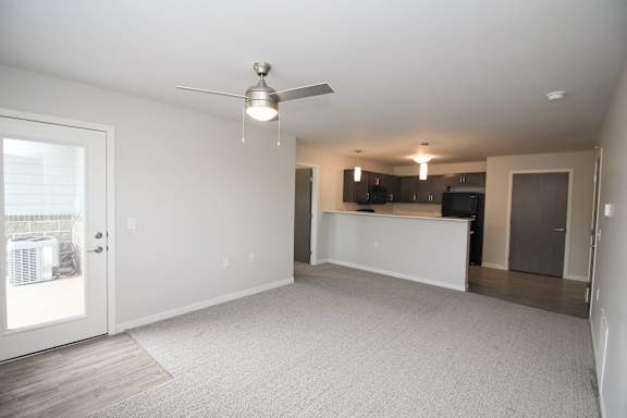 A spacious living room with a ceiling fan and a television.