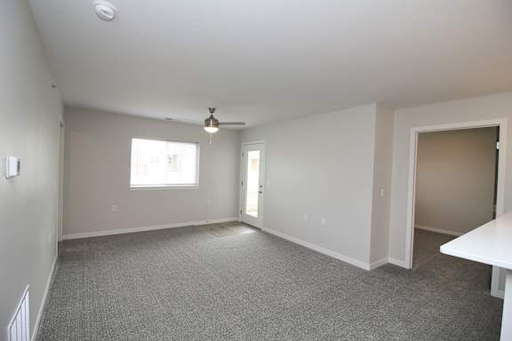 A spacious room with a ceiling fan and a window.