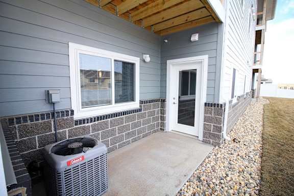 A house with a grey wall and a window with a white frame.
