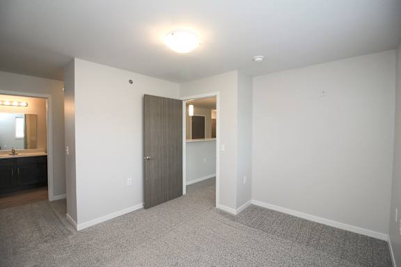 A large, empty room with a carpeted floor and white walls.