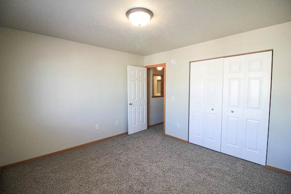 A room with a carpeted floor and a white door.