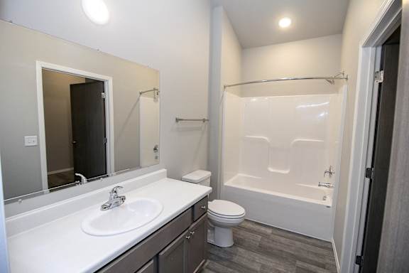 A bathroom with a white sink, toilet, and bathtub.