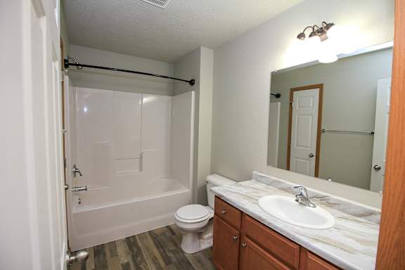 A bathroom with a toilet, sink, and bathtub.