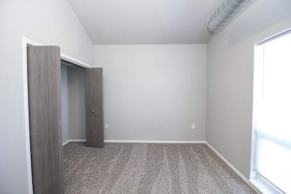 A room with a carpeted floor and a sliding door.