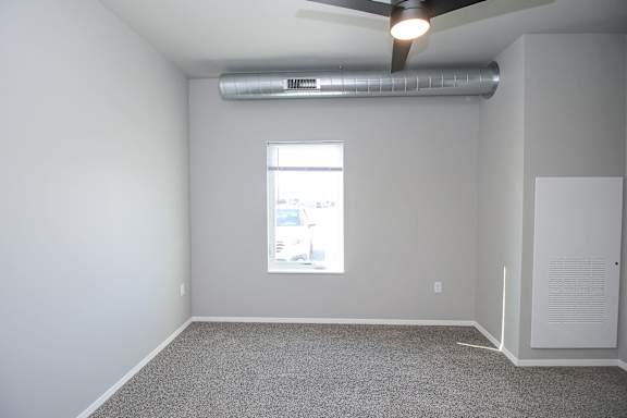A room with a ceiling fan and a window.