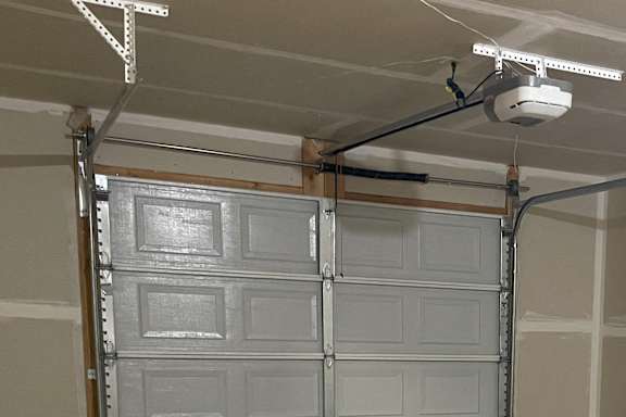 A long, narrow garage with a white door at the end.