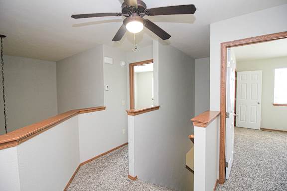 A room with a ceiling fan and a window.