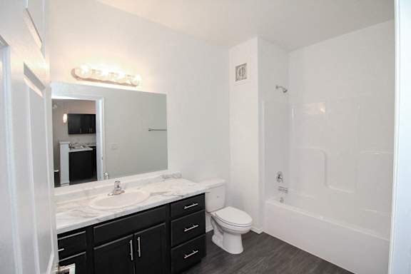 A white bathroom with a toilet, sink, and bathtub.