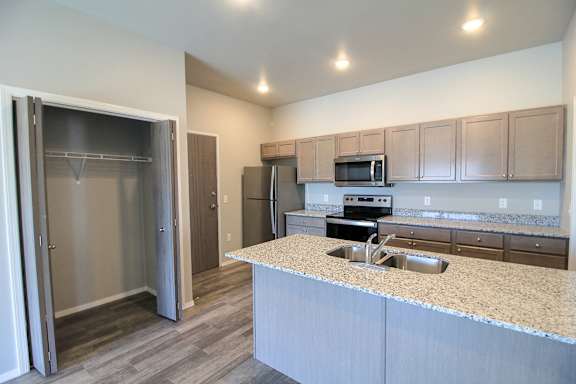 A kitchen with a sink, microwave, and refrigerator.