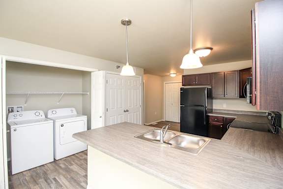 A kitchen with a washer and dryer in the laundry area.