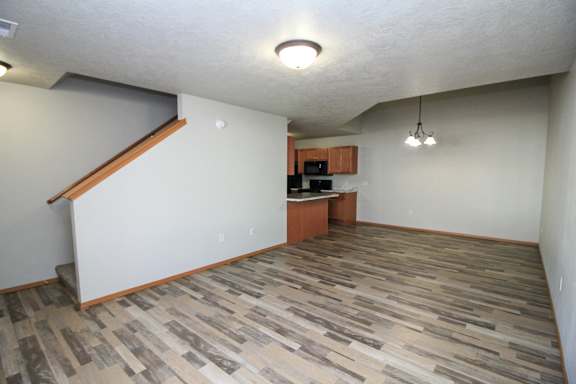 A room with a wood floor and a staircase.