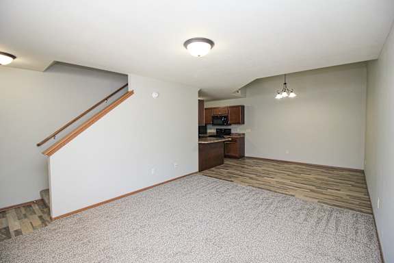 A room with a staircase and a small kitchenette.